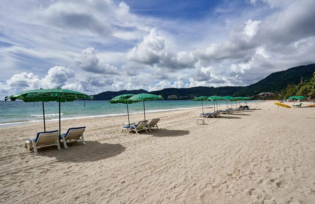 a sandy beach with lawn chairs and umbrellas